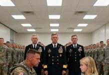 A decorated Navy SEAL admiral mocked the quiet, soft-spoken father in front of everyone, treating him like a joke—until someone accidentally mentioned the codename “Iron Ghost.” The entire room fell silent, officers stiffened, and the admiral’s smile vanished… because that was the name of the most feared operative ever to walk out of the shadows.