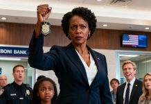 As soon as I walked into the bank lobby, I heard someone shout, “That Black girl! Call the police on her!” I saw my daughter standing frozen, eyes red, while two security guards moved toward her. My heart clenched. I marched straight toward them, my voice cold as steel: “Let her go.” The branch manager turned, smirking—until I held up my badge. His smile vanished instantly. “I’m the CEO of this bank. And that is my daughter.”