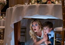 I was sitting calmly with my five-year-old son at my sister’s wedding reception when he suddenly squeezed my hand and whispered, “Mom… we need to go home. Right now.” I asked, “What’s wrong, honey?” He shook and said, “Mom… you haven’t looked under the table… have you?” I slowly leaned down to check— and my whole body went still. I held his hand firmly… and silently rose to my feet.