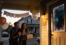 We arrived at my parents’ house for their anniversary celebration, carrying a gift. But as we reached the door, my husband glanced through the window and froze. His hand tightened around mine. “Don’t go in,” he whispered, shaking. His face had gone completely white. “We have to leave.” I set the gift on the porch and turned away. But what happened on the drive home still haunts me.